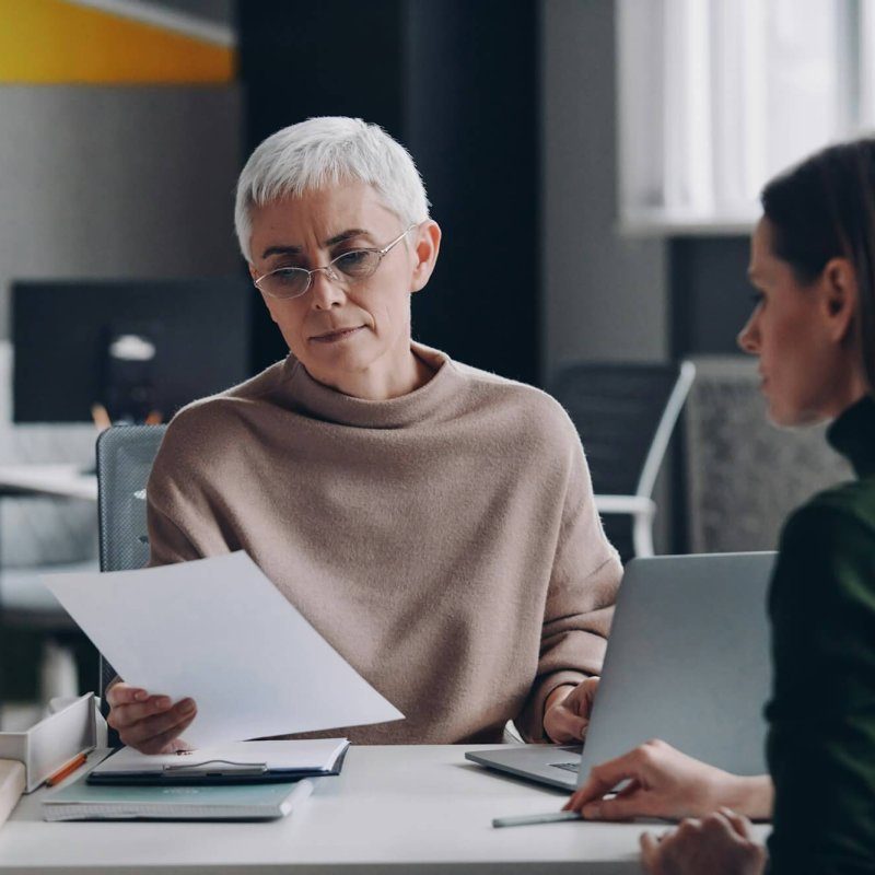 senior-female-hr-manager-examining-application-while-having-interview-with-young-woman-qw26g7ov7bo02iin6c8xalmj7jeqec61c2nfzq6la8